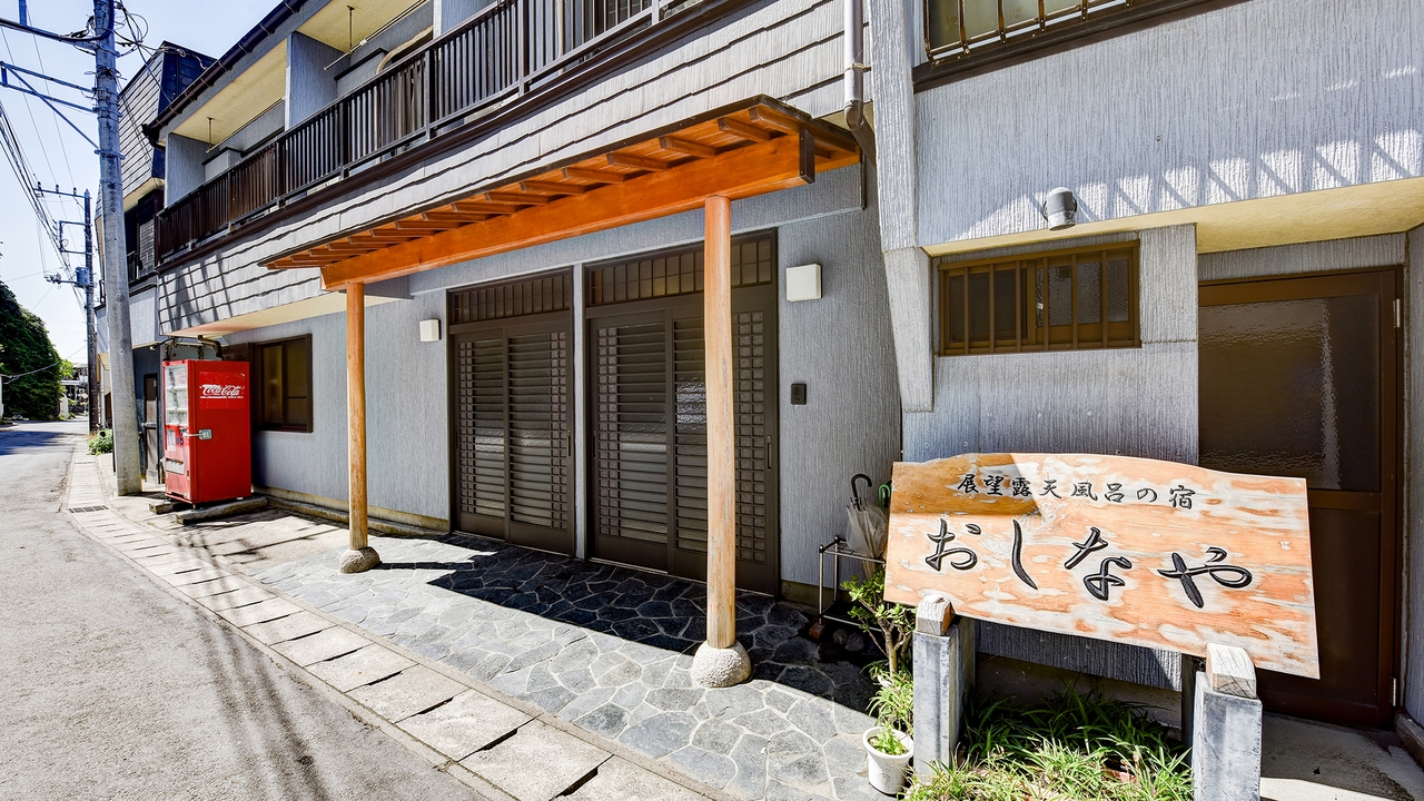 海と夕日の展望風呂の宿おしなやの外観。「おしなや」の看板が掛かる勝山の民宿
