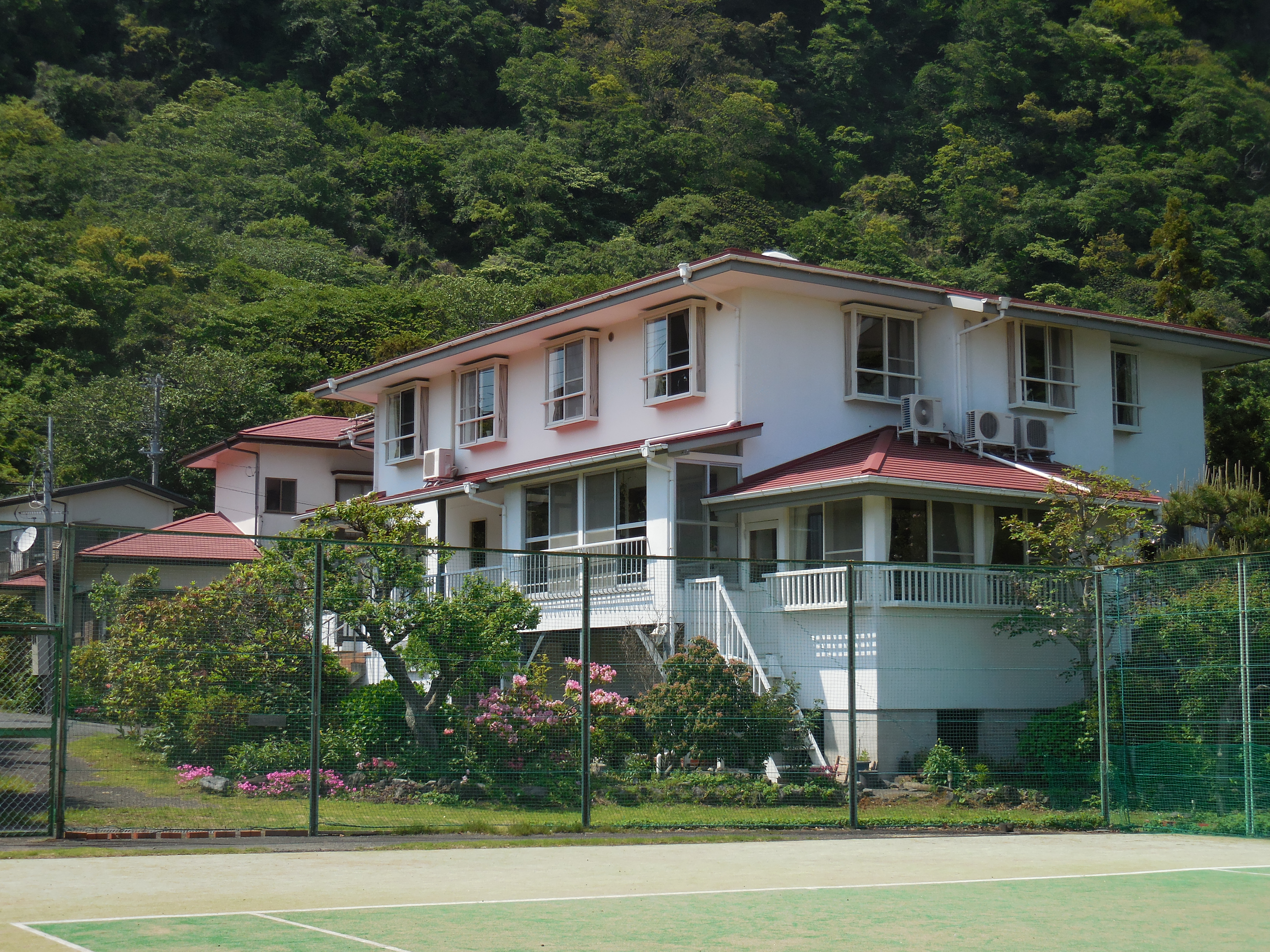 オムニテニスコート2面からペンションの外観