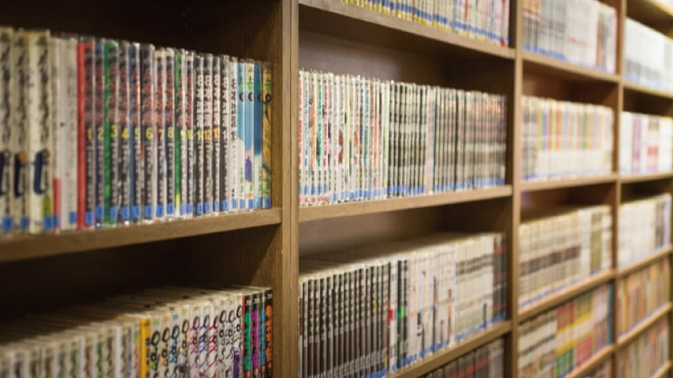 クレスト松戸の漫画の本棚。木の棚に単行本がぎっしり並んでいる