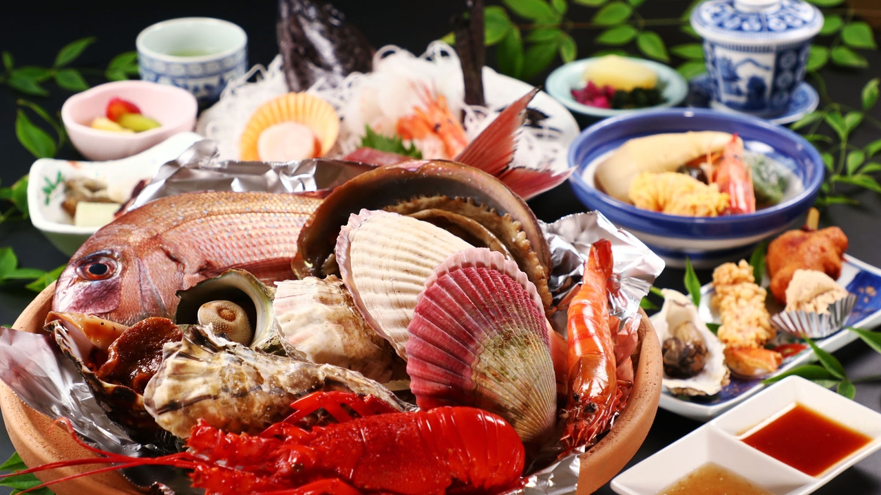 活魚民宿 豊の宝楽焼き。伊勢海老・あわび・鯛・ホタテ・牡蠣が大鉢に盛られている