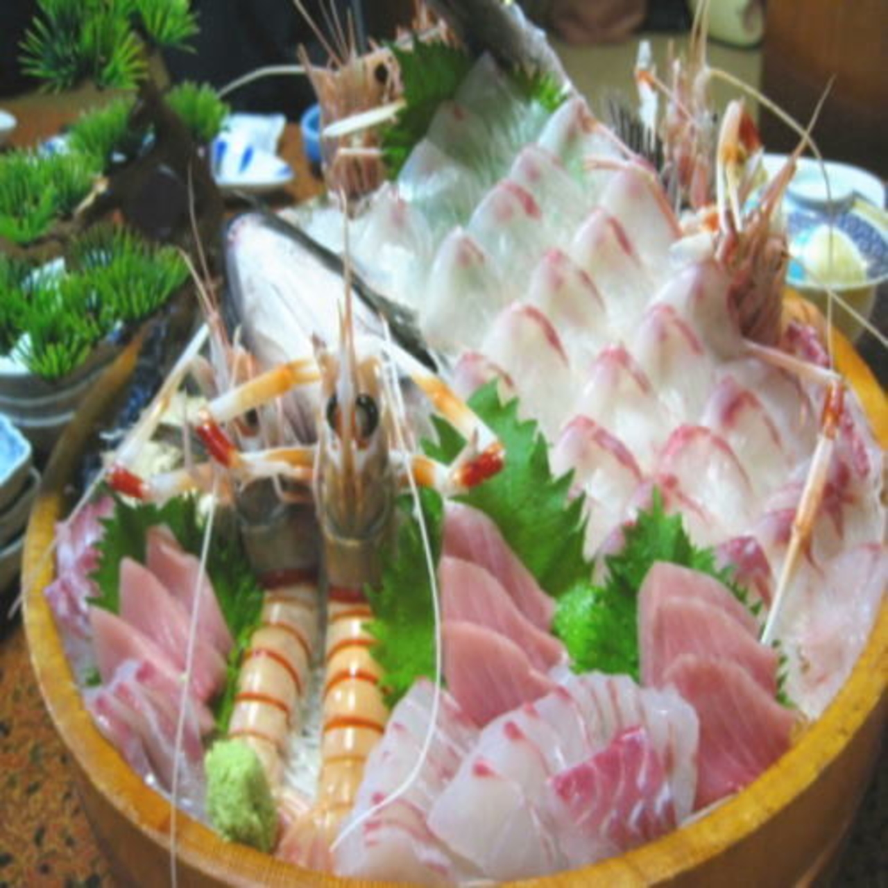 富久三苑の夕食の船盛り。白身魚の薄造りと赤身、えびが桶いっぱいに盛られている