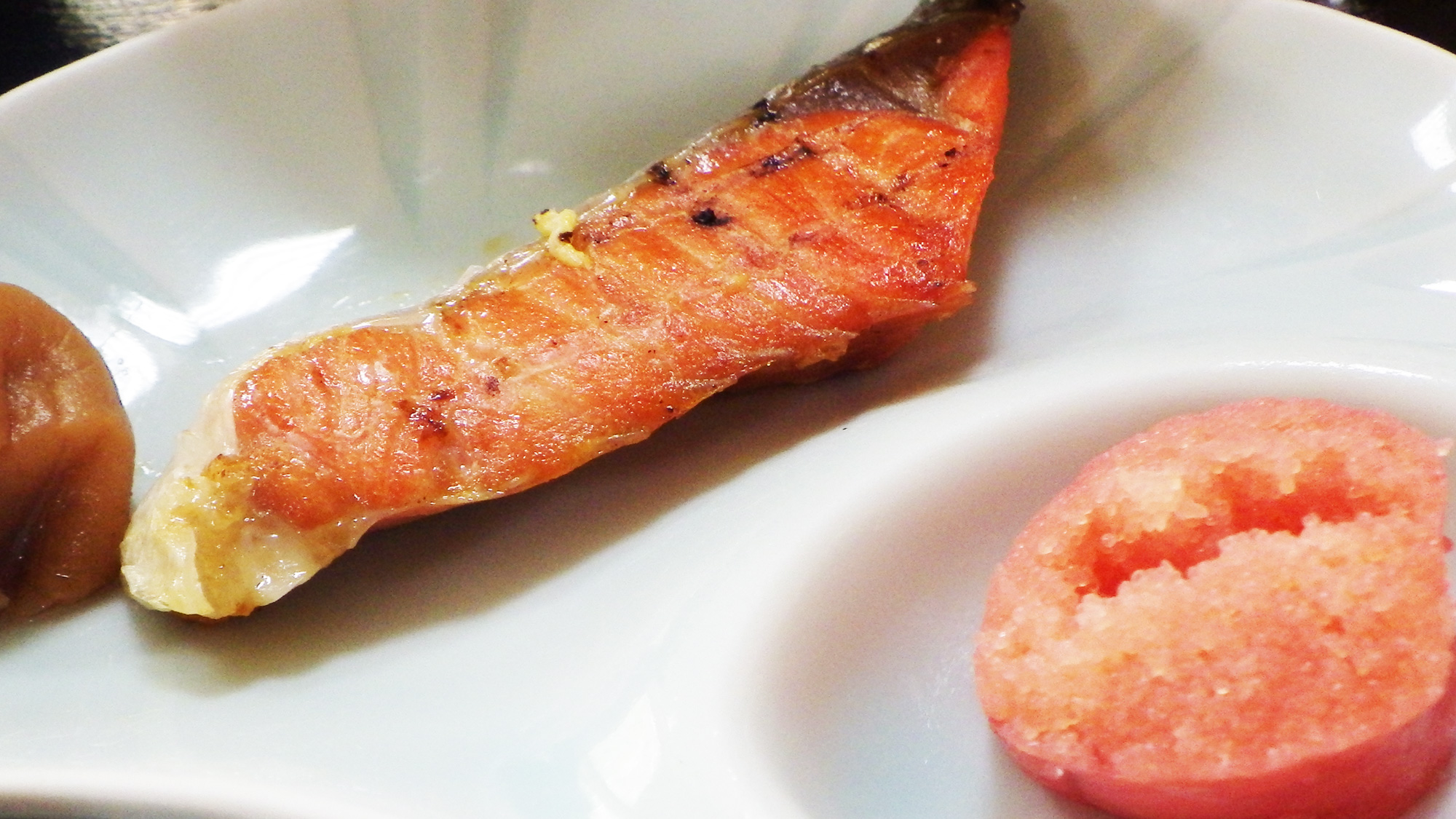 *朝食（一例）白いご飯にぴったりな焼き鮭、梅干し、たらこ。