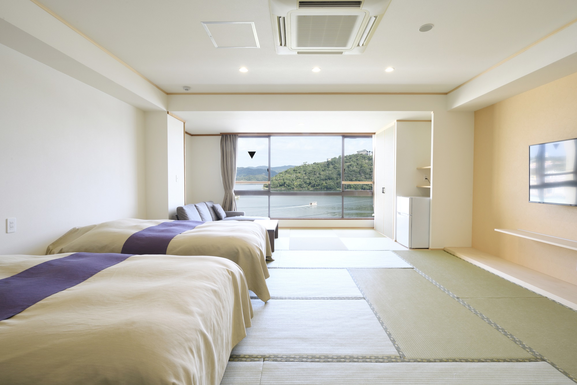 15畳の広々とした和室にセミダブルベッドを2台備えた、和と洋の快適さを兼ね備えたお部屋です。お部屋は段差のないユニバーサルデザインで、お子様からご高齢の方まで安心してお過ごしいただけます。 大きな窓からは、四季折々の表情を見せる浜名湖の絶景を一望。朝のやわらかな光や夕暮れの幻想的な風景が、心を穏やかに癒してくれます。ゆったりサイズのベッドで、旅の疲れもゆっくりと癒してください。 家族旅行やご夫婦でのご滞在にも最適な、快適さとやさしさに包まれた客室です。