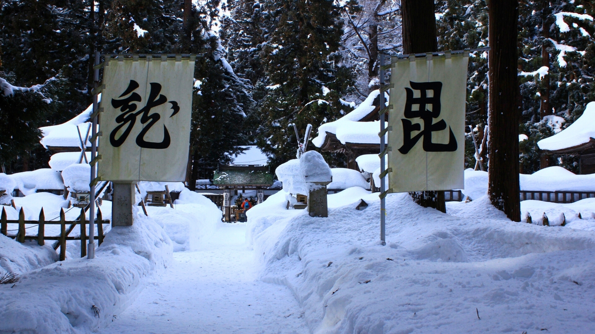 雪に包まれた上杉神社。謙信が用いた「毘」「龍」の旗がはためきます。