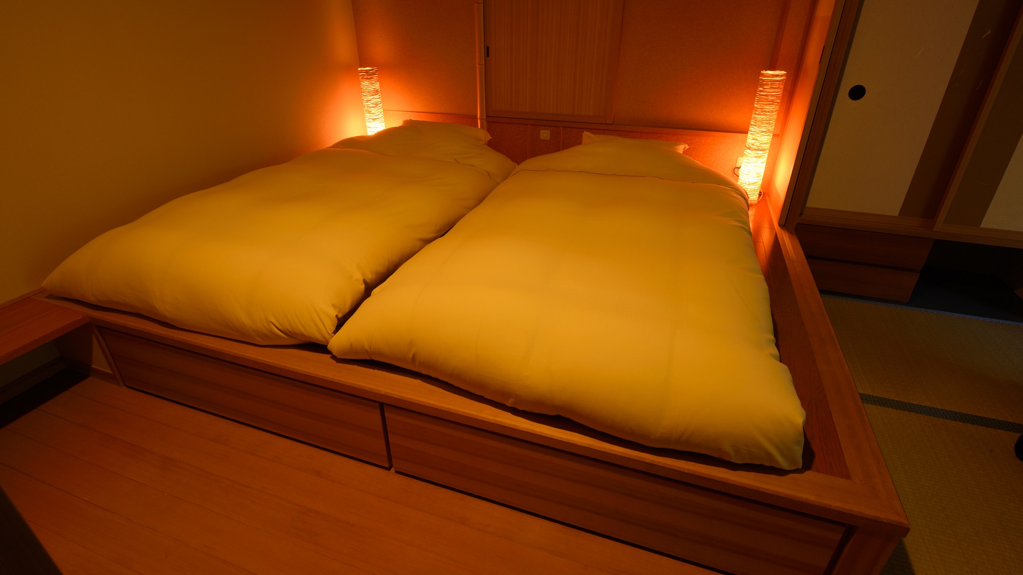 客室の寝具は小上がりの上にマットレス＋布団の和風ベッドでご用意しております。