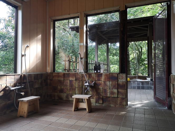 「竹の湯」の洗い場。シャワーは２つで、扉の向こう側に露天風呂があります。