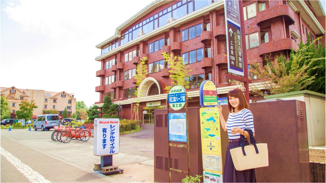 ホテル目の前のバス停は河口湖周遊バスNo5「河口湖ハーブ館」です。

河口湖周遊バス（レッドライン）
河口湖駅から運行しており、「～河口湖～富士山パノラマロープウェイ」・「河口湖美術館」・「河口湖音楽と森の美術館」・「自然生活館」などの観光施設を巡る大変便利なバスです。河口湖の東部には温泉街、北側の湖畔には美術館やカフェなどが集まり、多くの観光客で賑わっております。