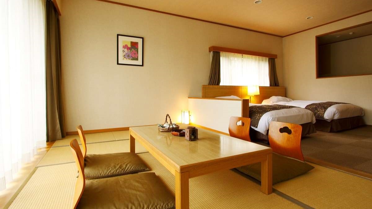 【広々ゆったり和洋室】高さのあるベッド2台を備えており、畳にはお布団を敷くことも。