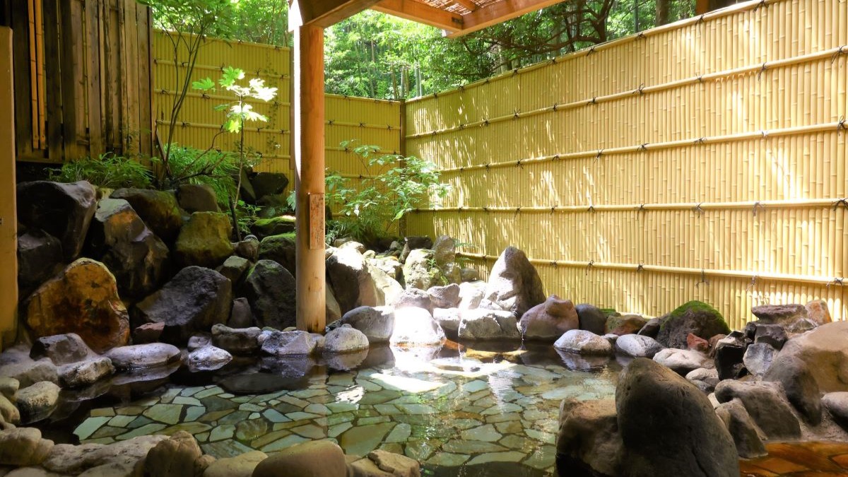 【大浴場露天：花の湯】開放的な緑の庭を眺められる岩露天風呂。