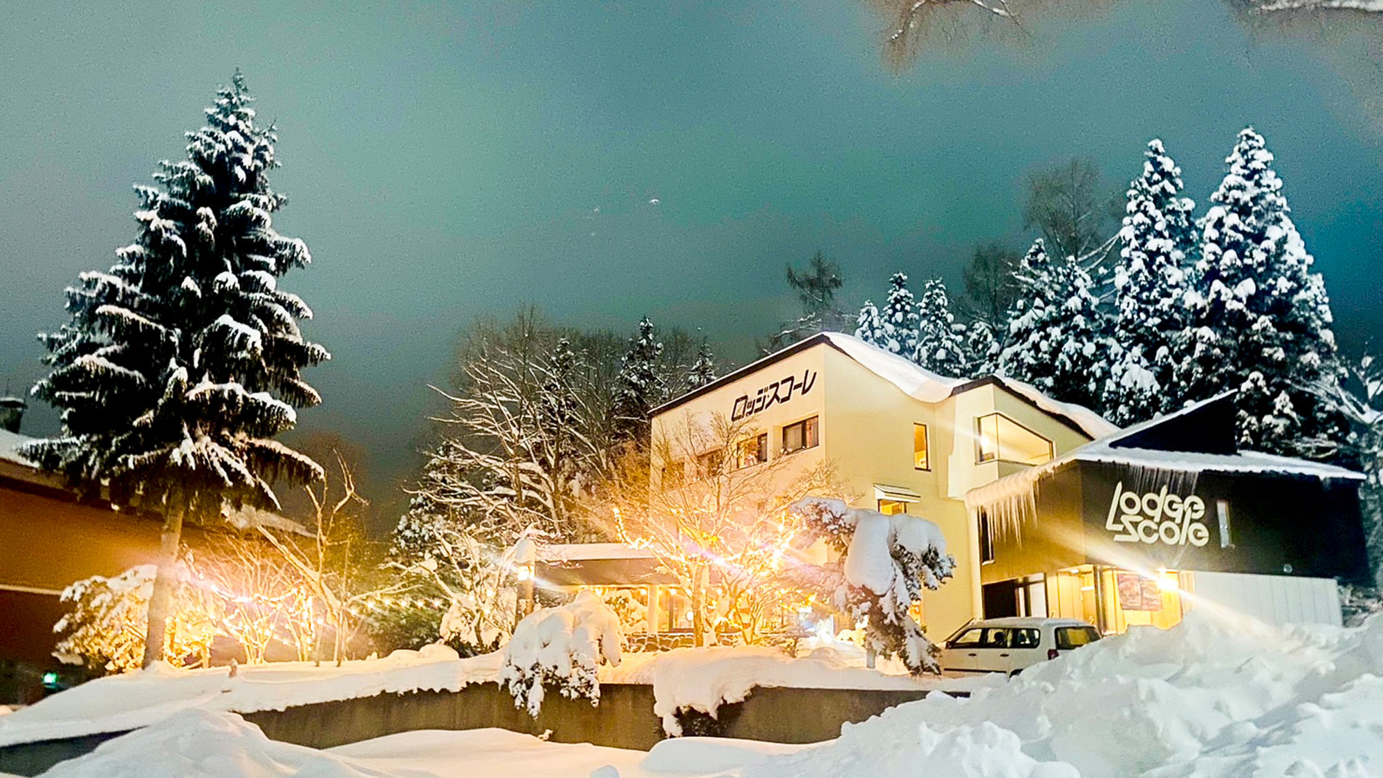 ・【夜の外観】雪に包まれイルミネーションの灯りに照らされるロッジスコーレ。心あたたまる冬の宿へ