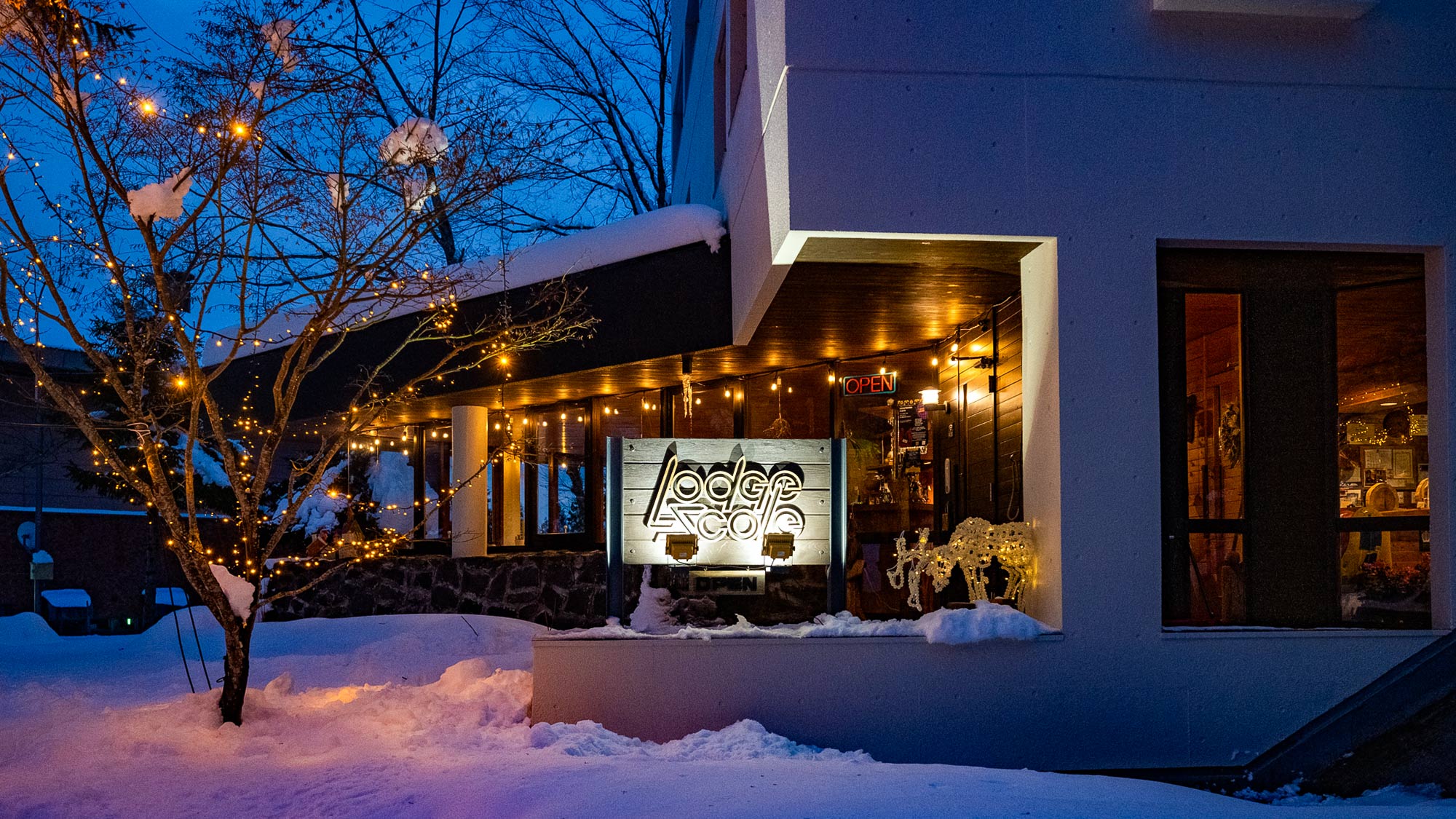 ・【施設看板】温かい光に包まれる、冬のロッジ