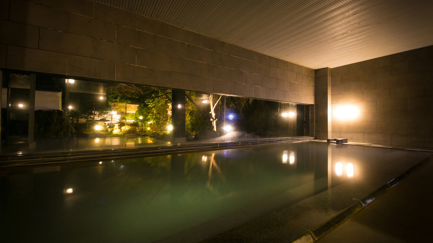 【大浴場】夜になるとライトアップされた日本庭園と白濁したお湯が共鳴し、幻想的な世界を作り出します。