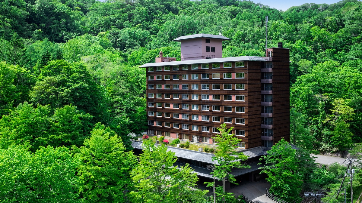 夏の緑に囲まれた望楼NOGUCHI登別の外観