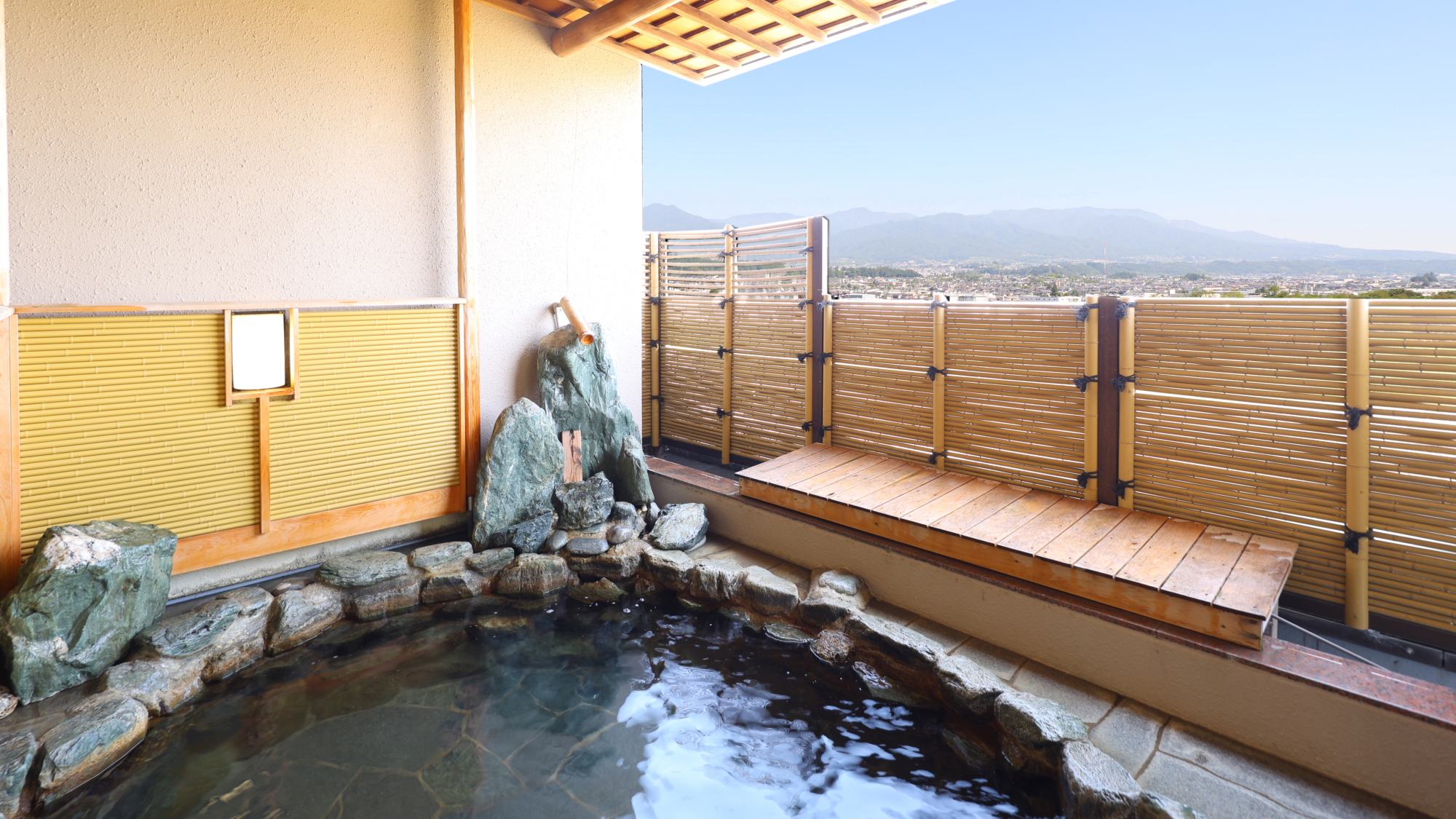 □【大浴場・露天風呂】昼は天竜川の悠々たる流れ、夜は飯田市街地の夜景を一望します
