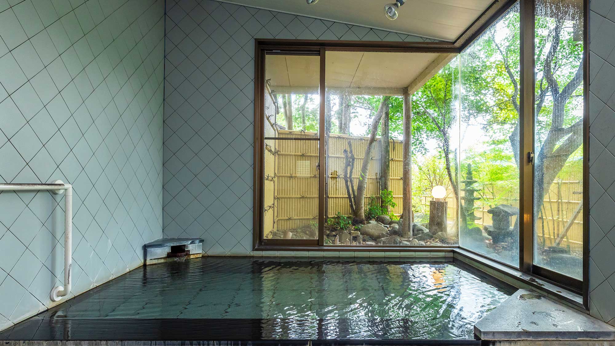 【日帰り温泉／ほの香】大きな窓に面した内湯。庭園風の景色を楽しめます。