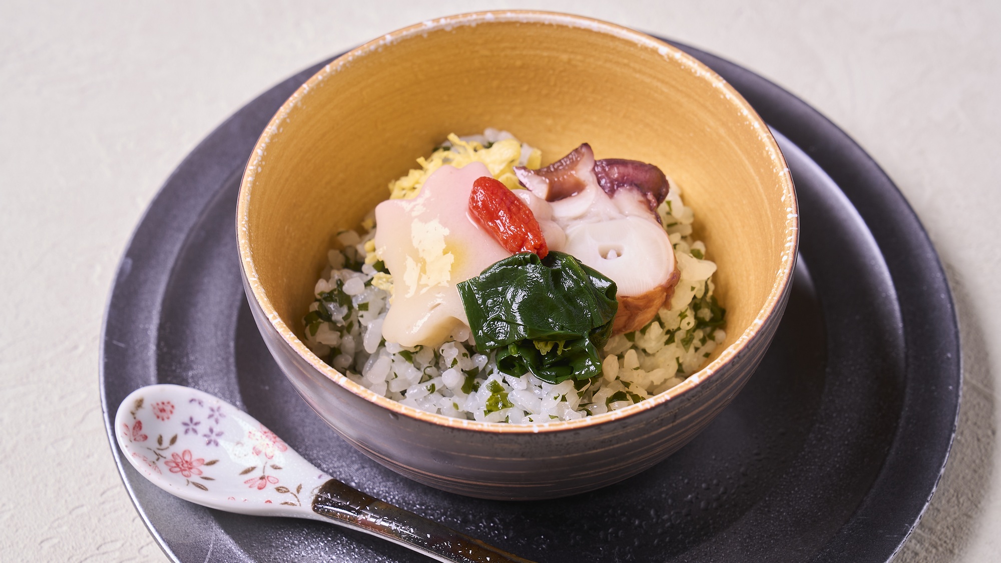 ・【春料理一例・凌ぎ】若布御飯　蛸柔煮　紅甲餡　桜麩　錦糸玉子　法蓮草