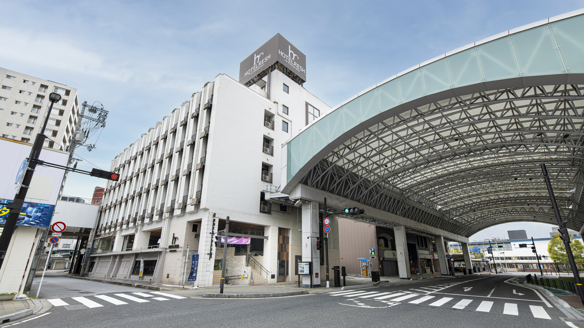 鳥取駅北口を出てすぐ、白い外壁とモダンなデザインが特徴のホテルです。 駅前のメインストリートに位置し、夜遅くのご到着でも明るい道を通ってお越しいただけます。周辺には地元の飲食店やコンビニが多数あり、お食事や急なお買い物にも困らない便利な立地です。鳥取砂丘へのバス乗り場も近く、アクティブな旅にぴったりのロケーションです。