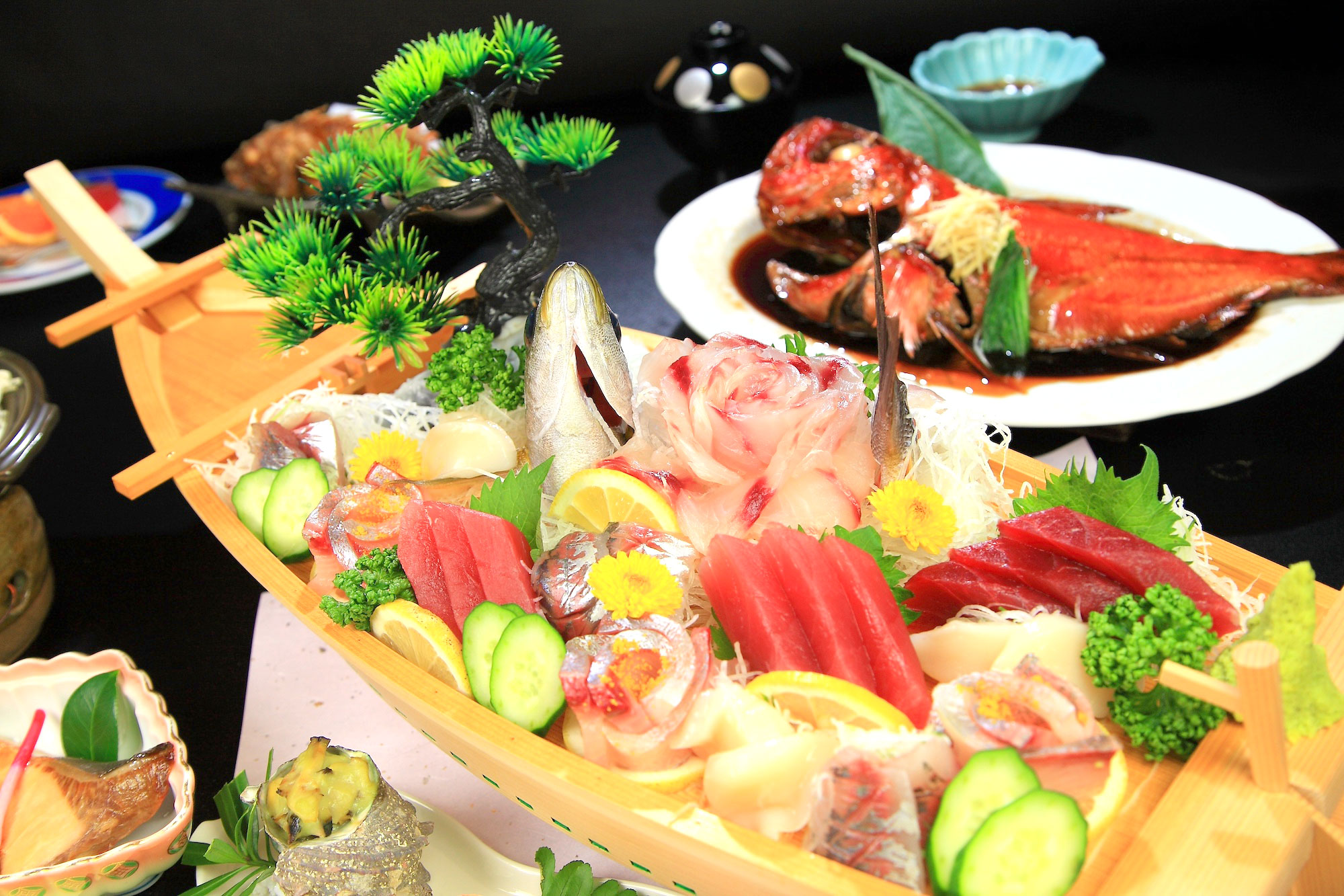 弓ヶ浜いち番館の夕食。地金目鯛の姿煮と舟盛りが並ぶ