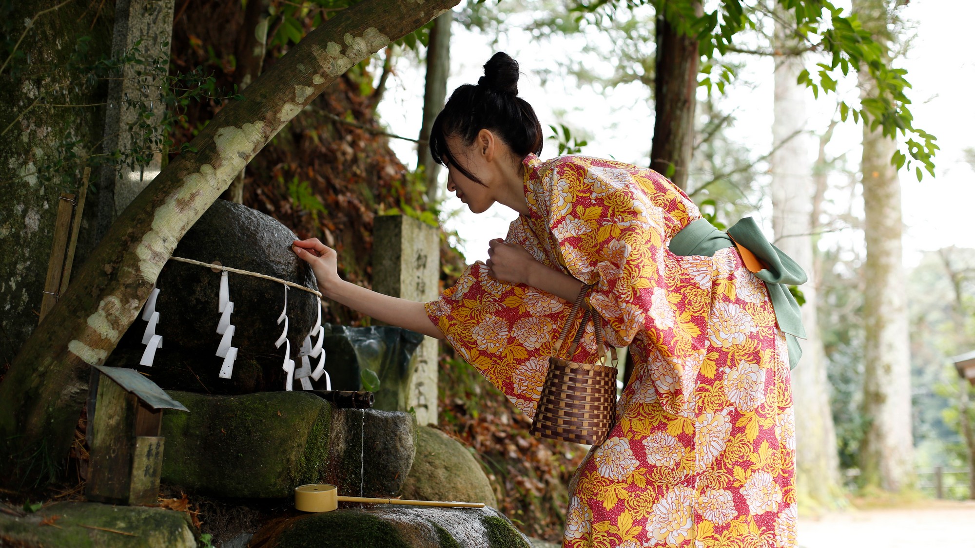 【願い石】  玉作湯神社境内に祀られている「願い石」に「叶い石」を触れさせて祈ります。