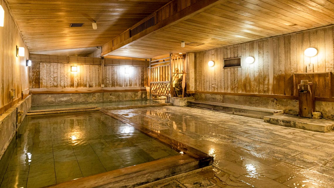 湯治場の趣を残した檜大浴場「薬師の湯」。檜と群馬県の銘石で作った湯舟が2つずつあります。