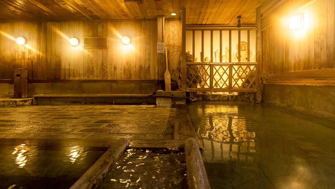 湯治場の趣を残した檜大浴場「薬師の湯」。檜と群馬県の銘石で作った湯舟が2つずつあります。