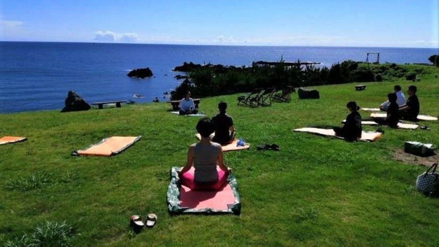 ▲芝生の上で心地よい潮風を浴びながらの朝ヨガ