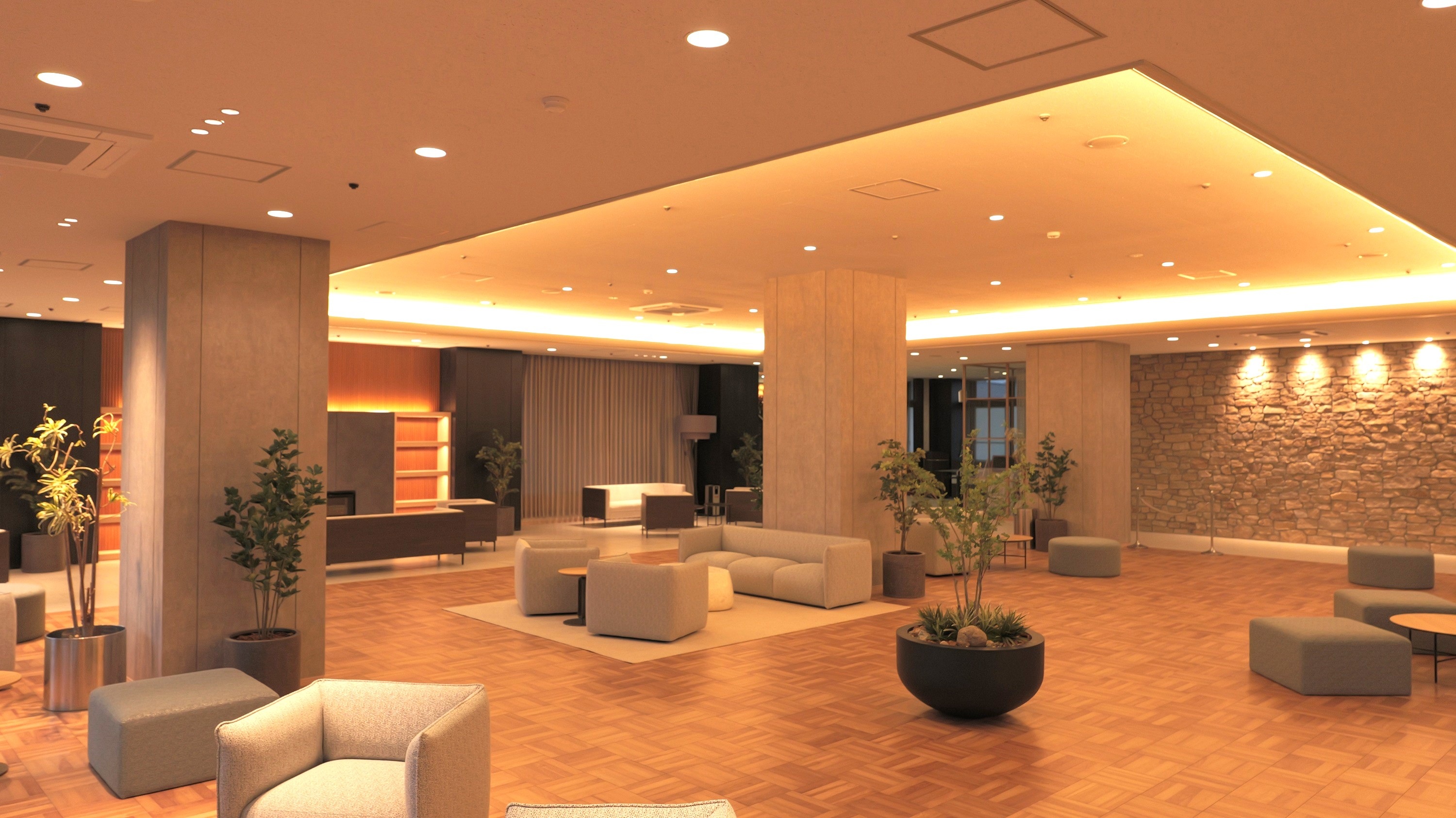 自然豊かな野山イメージして、優しい木目と柔らかい照明、活力のある植栽を配置し、 ナチュラルでリラックスできる空間としました。 一部に津山城の石垣をイメージした壁面を施してあります。 