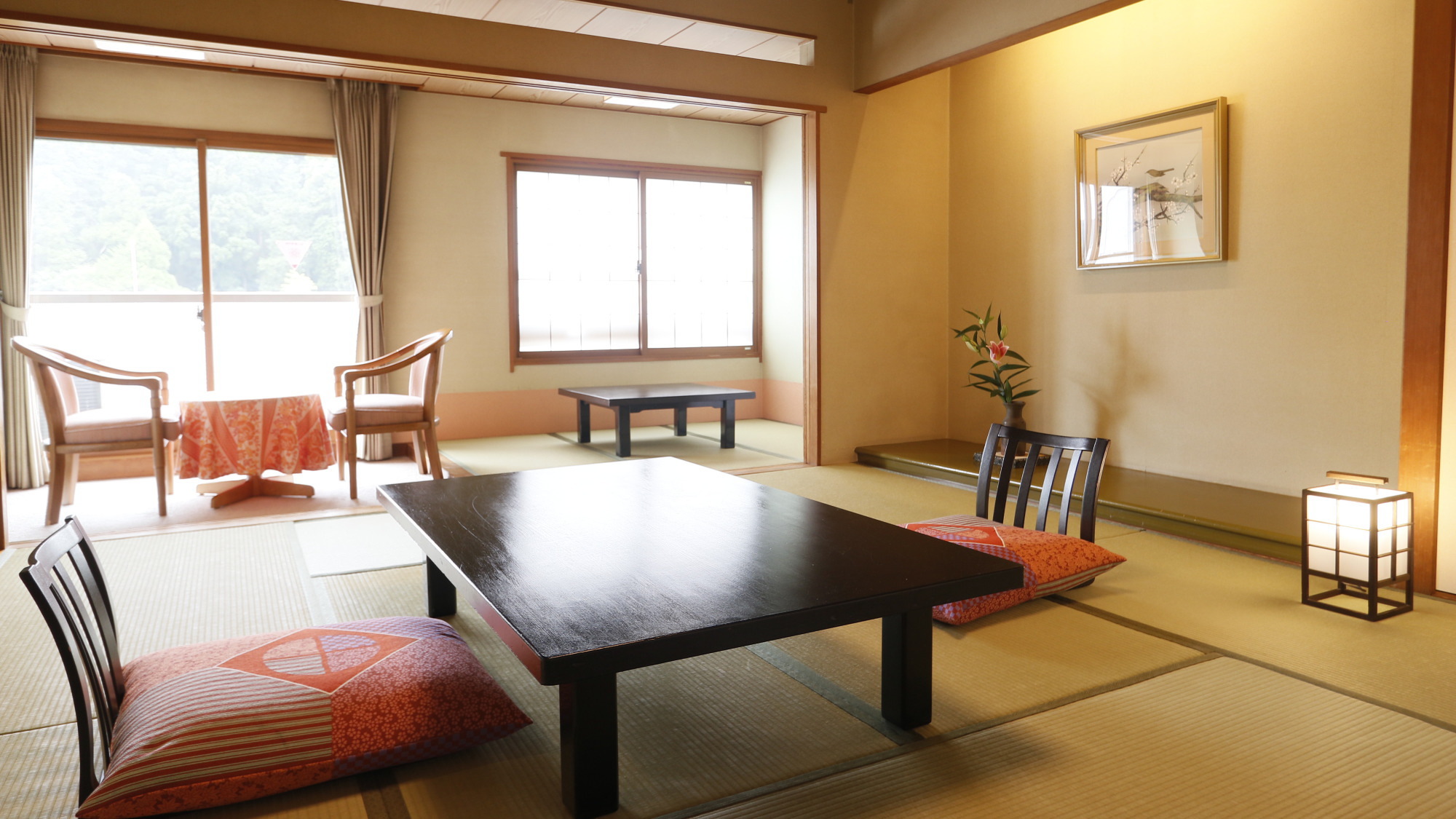 【元禄館：和室】窓際には絨毯のスペースにテーブルと椅子をご用意しており、 バルコニーもございます。