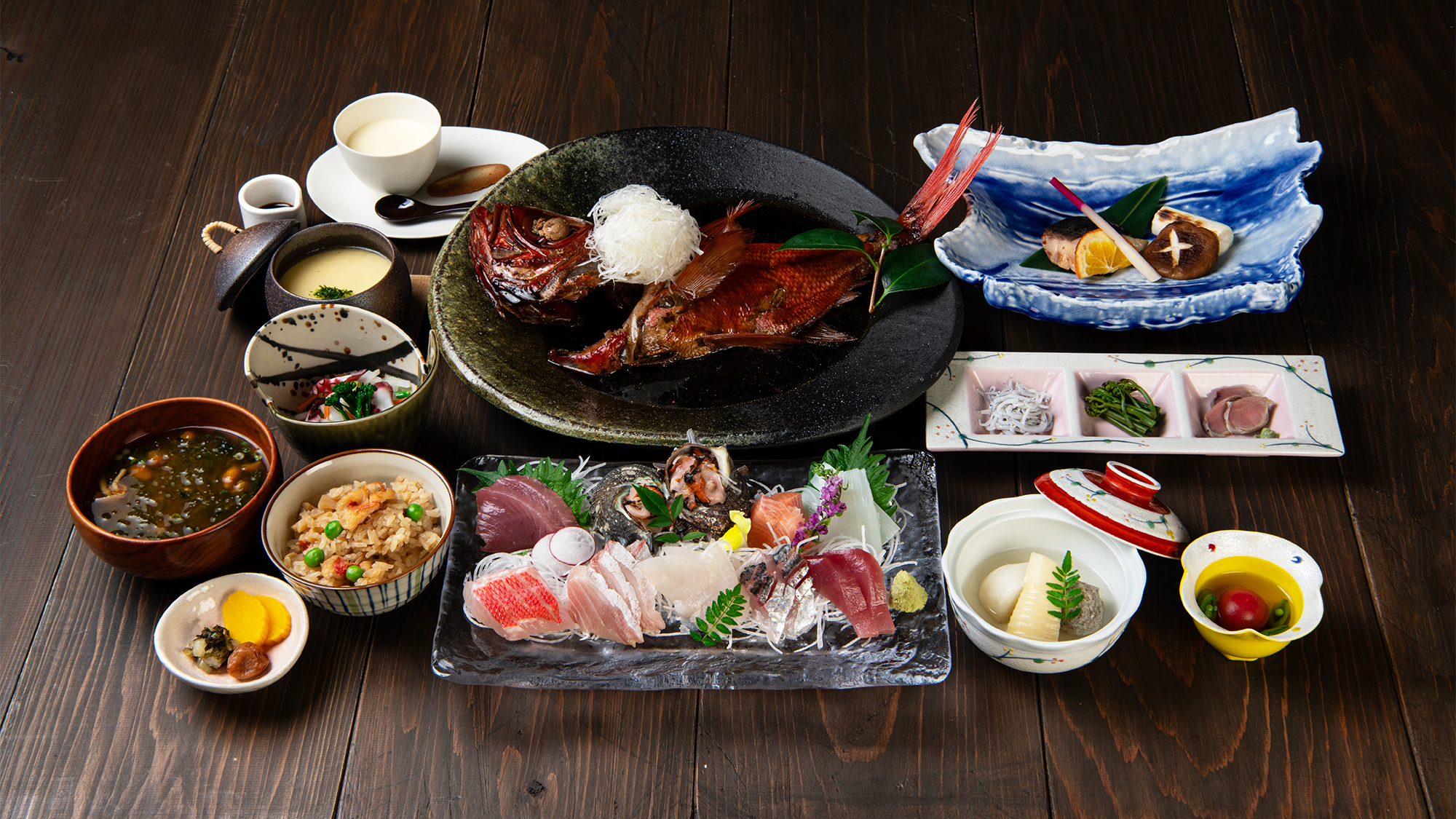 こころねの夕食。特大金目鯛の姿煮と刺身、小鉢が並ぶ
