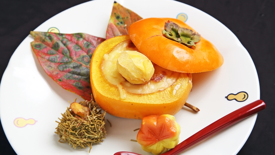 【夕食・焼き物】秋の焼き物一例・柿をくり貫いた中は蟹や丹波の黒豆が入ったグラタンになっております。 