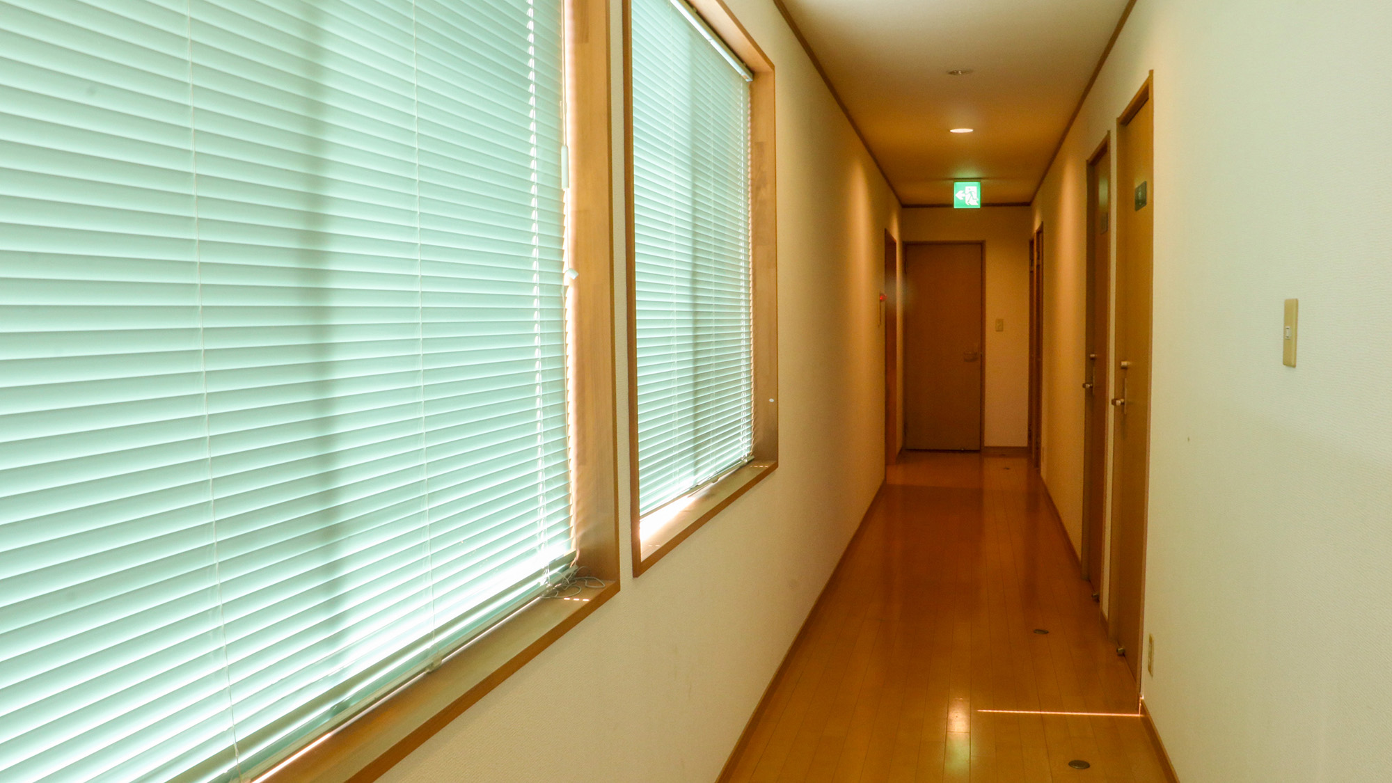 #館内　やわらかな照明が迎える、落ち着いた廊下。