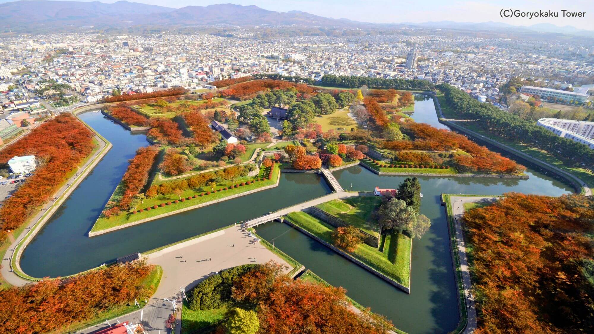 【秋の五稜郭公園】お車約60分。紅葉に彩られる五稜郭。堀の水面に映る赤や黄色の景色は、風情満点です。