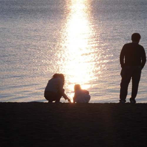 夕陽の中で遊ぶ家族