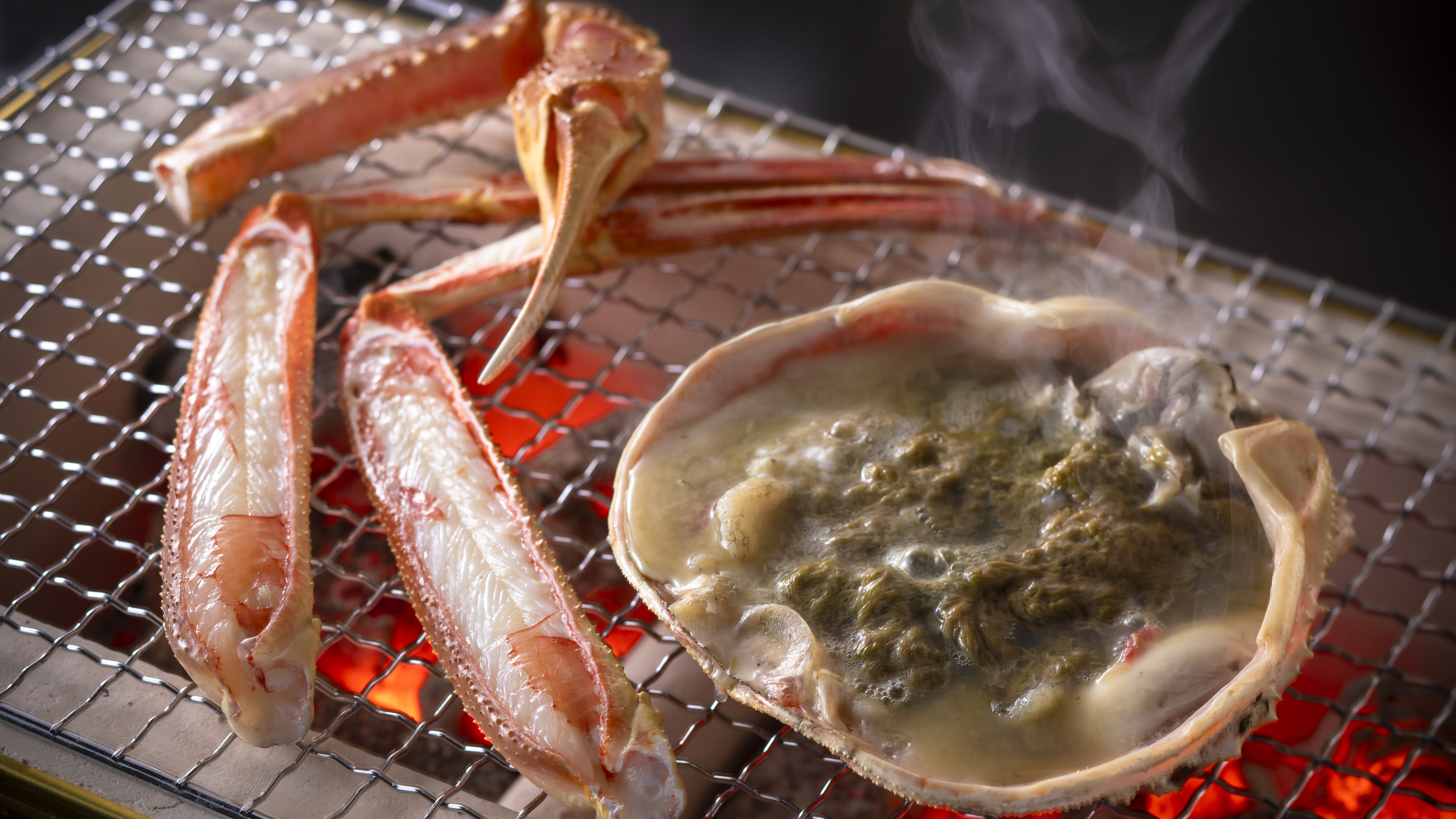 【焼き蟹】炭火で香ばしく焼き上げる活松葉蟹の焼き蟹は、ぷっくりとした身、濃厚な味噌が極上です。