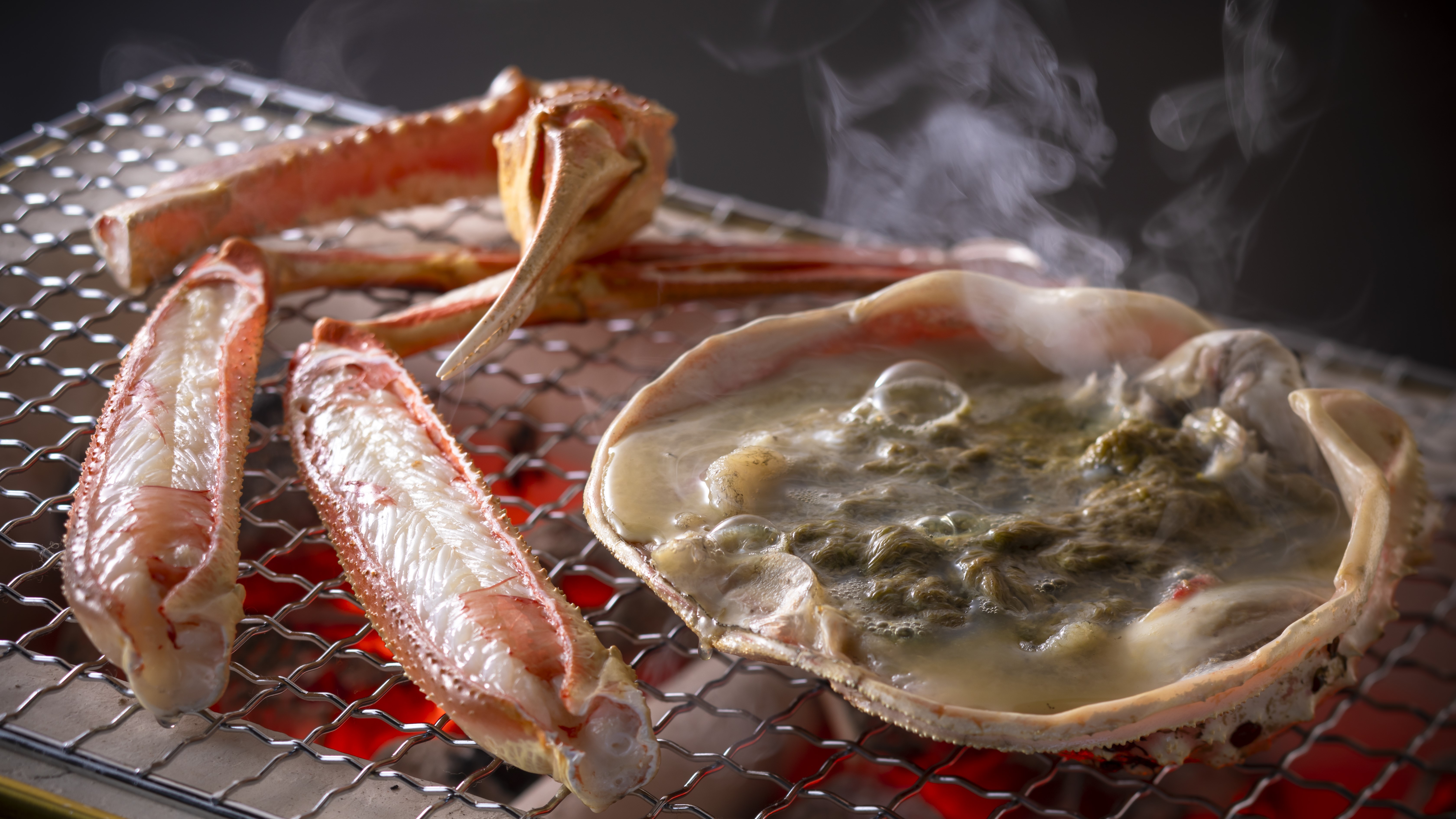 【焼き蟹】炭火で香ばしく焼き上げる活松葉蟹の焼き蟹は、ぷっくりとした身、濃厚な味噌が極上です。