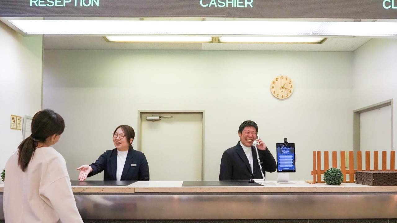 スタッフが笑顔でお出迎え。慣れない土地でのご宿泊も、安心してお過ごしいただけるよう真心を込めた接客を心がけております。チェックイン・アウトのお手続きはもちろん、周辺情報の案内や、急な困りごとにも丁寧に対応いたします。心安らぐ「旅の拠点」として、皆様のお越しをお待ちしております。