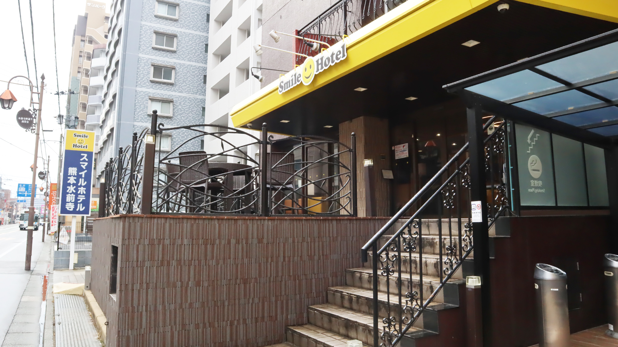 ホテル外観。黄色の看板、茶色の建物。新水前寺駅より徒歩3分！