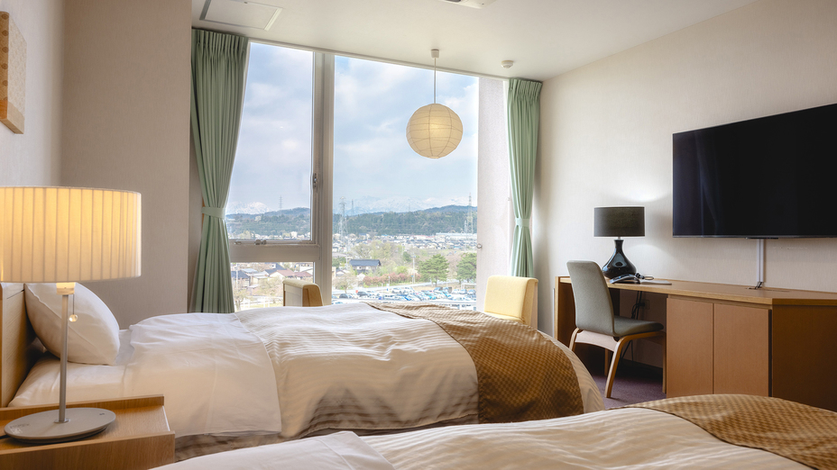 【ツイン】セミダブルベッドでゆったり。天気が良ければ、窓から立山連峰を望むことができます。