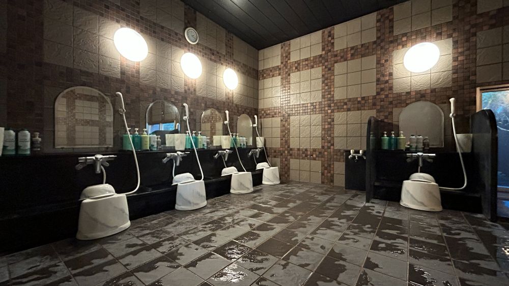 【男性大浴場内浴室①】カランは5箇所ございます。シャンプー・シェービングクリームも完備しております。