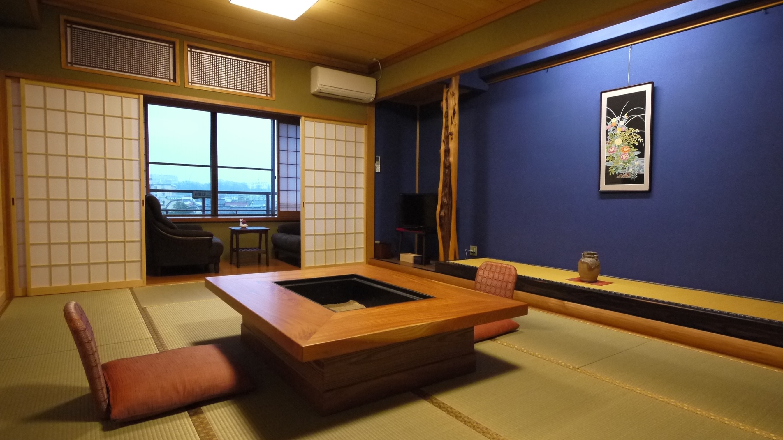 【スイート「古代紫」居間】12畳が二間続いたお部屋。群青色の床の間に加賀友禅の軸を掛けました。