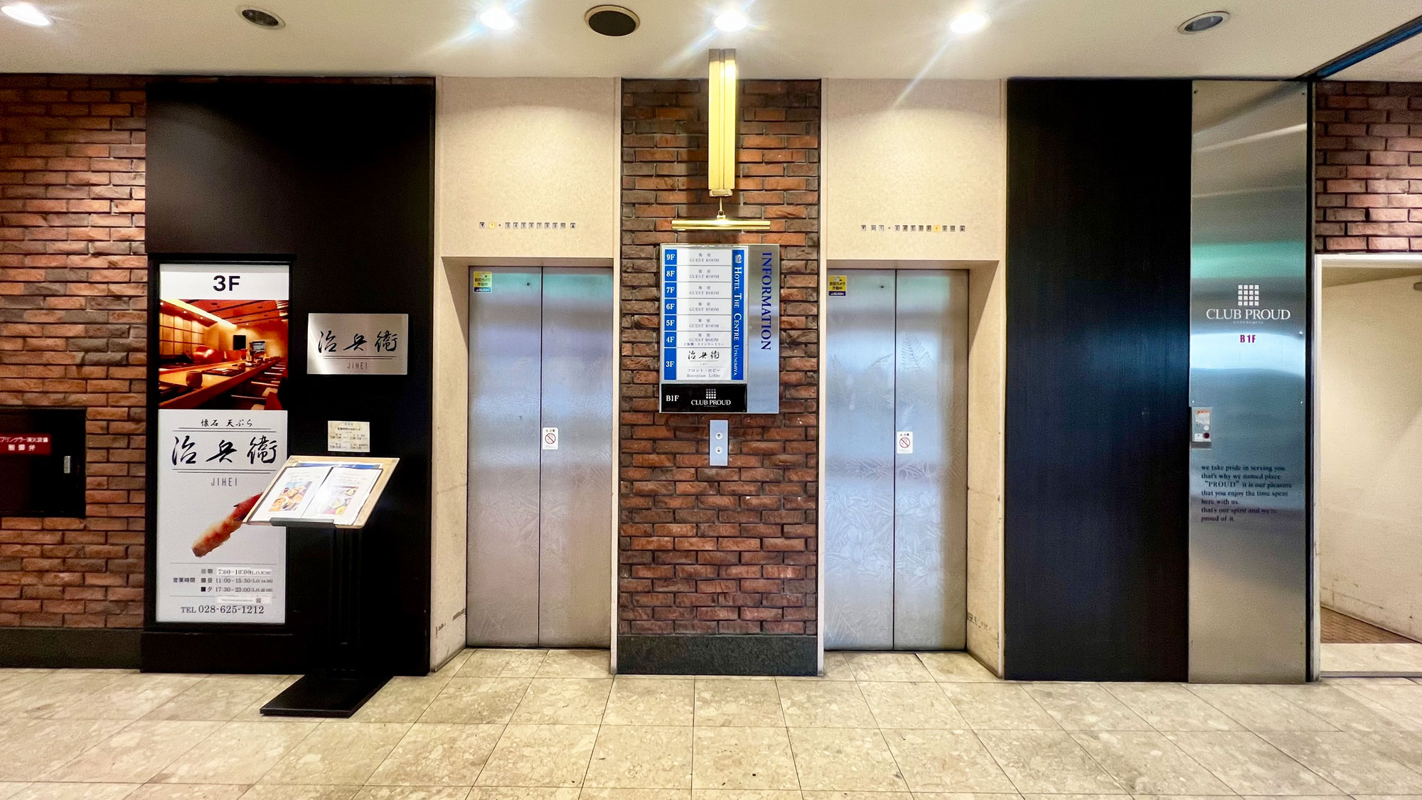 【ホテル建物入口　フロントはエレベーターでお上がりください】