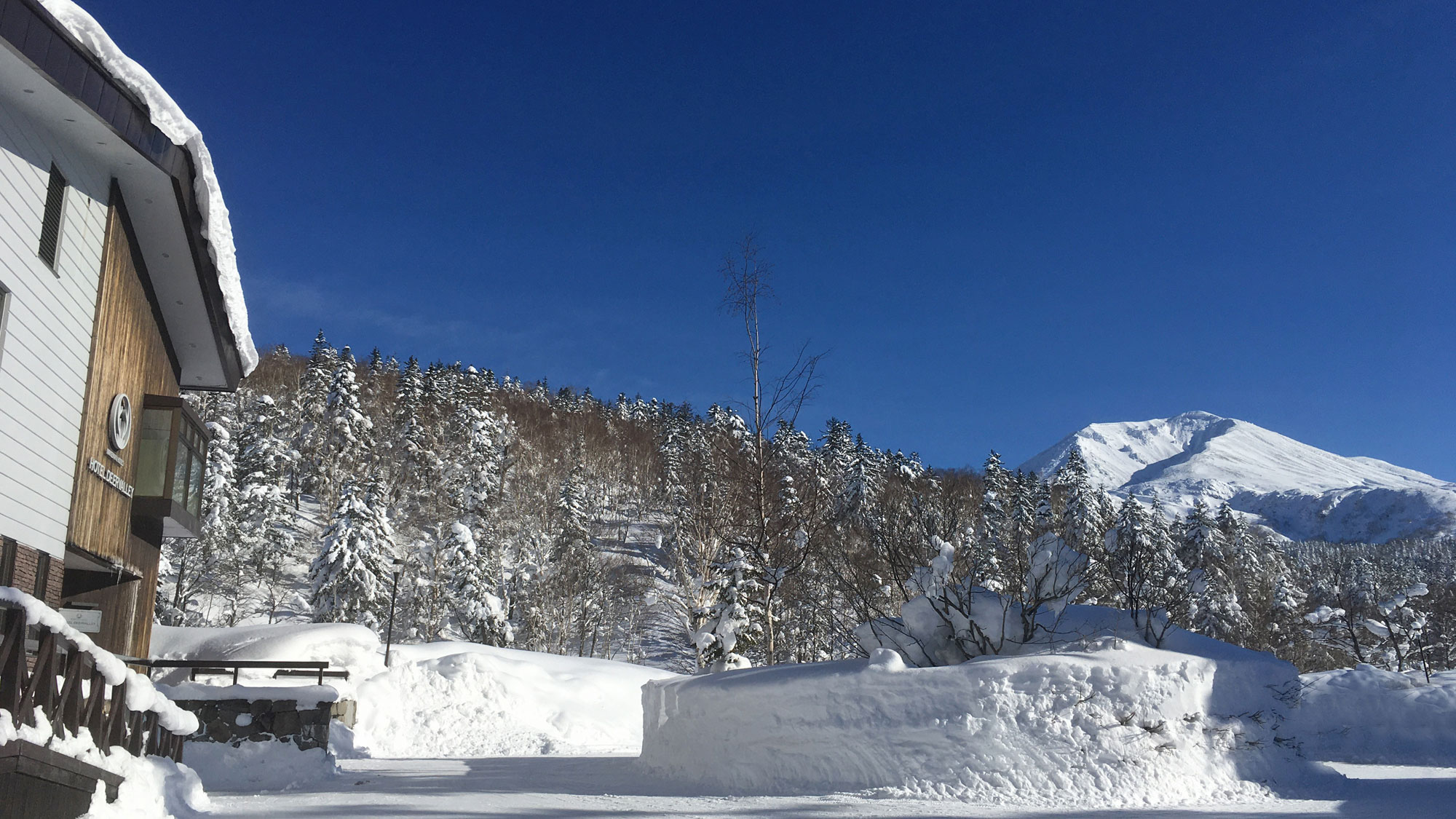 雪景色の旭岳とディアバレー外観