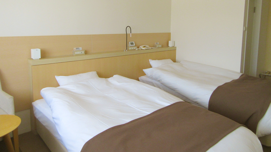 ハイフロアツインルームの2台のベッドは通常は離れた配置ですが、添い寝ありの場合は繋げてご用意します。