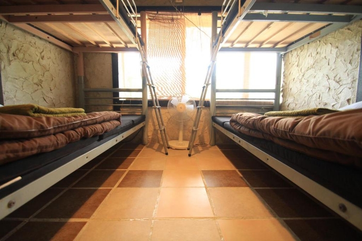 ドミトリールームは沖縄漆喰壁にイタリアンタイルの床、沖縄古材の木材