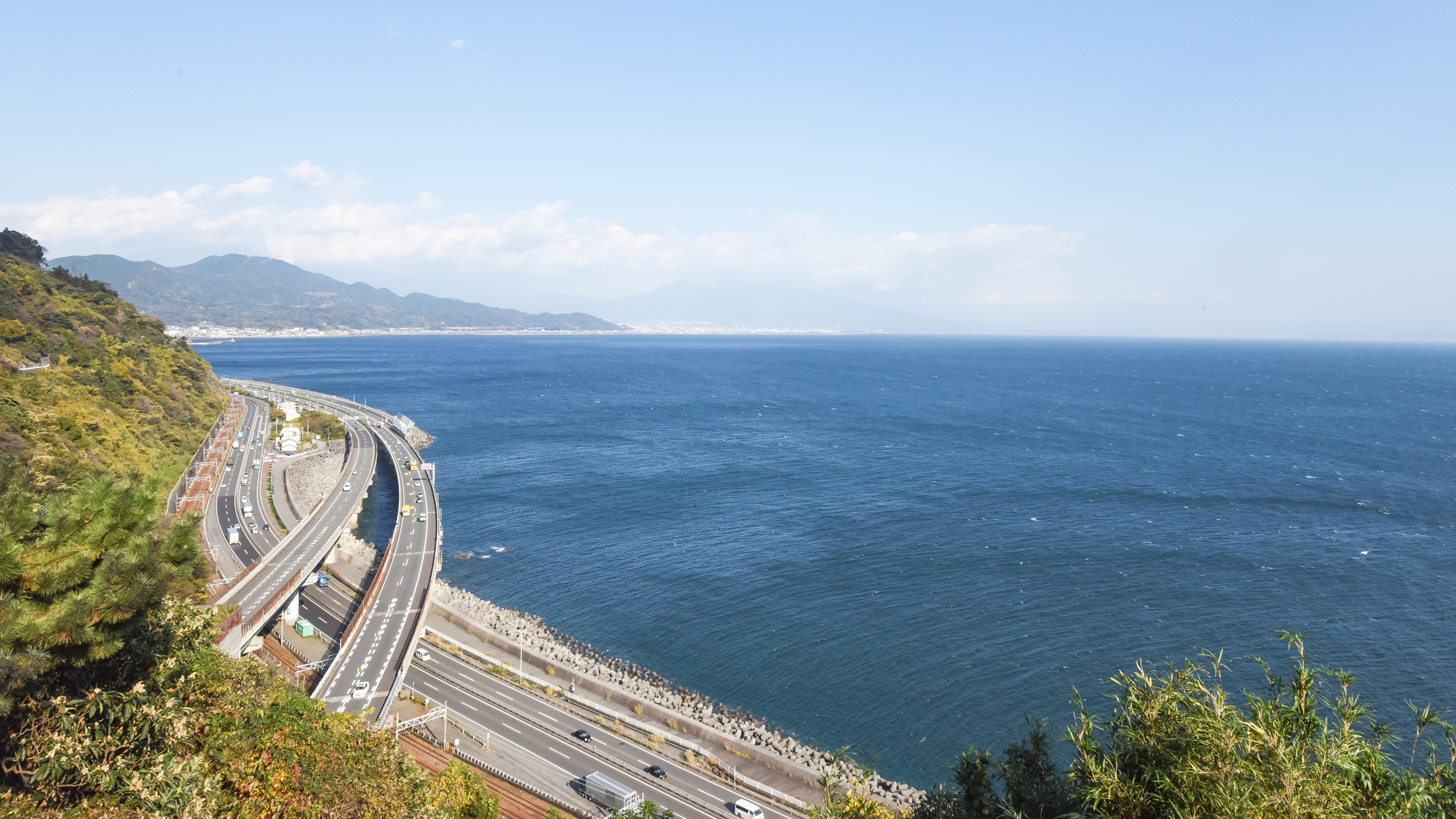 *【周辺／薩た(さった)峠】背景に富士の山。崖と海に、鉄道・国道・高速道路の３つの線が走ります