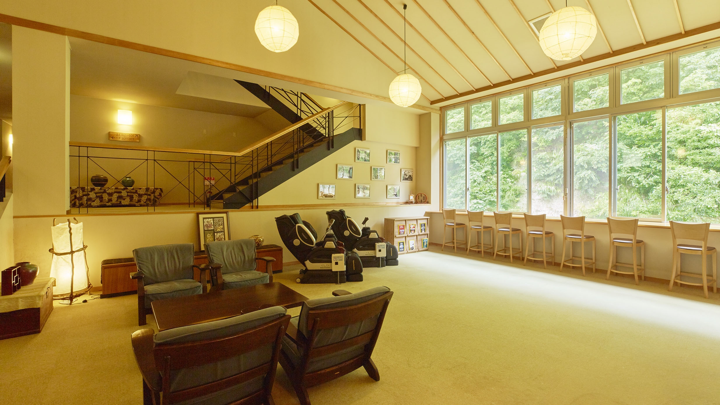 【休憩処】大きな窓が開放的。ソファやマッサージチェア、山を望むカウンターは休憩にぴったり。