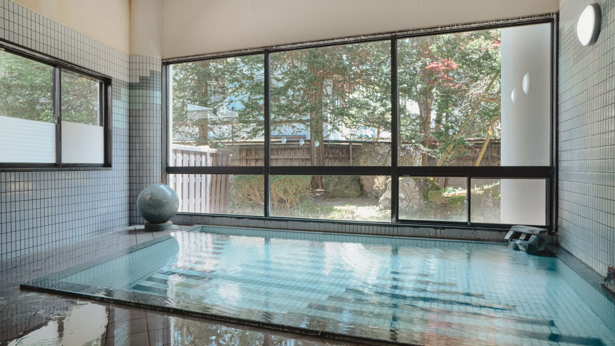 【男性大浴場】明るい日差しが差し込む大きな窓から、四季折々に美しいお庭が楽しめる大浴場。
