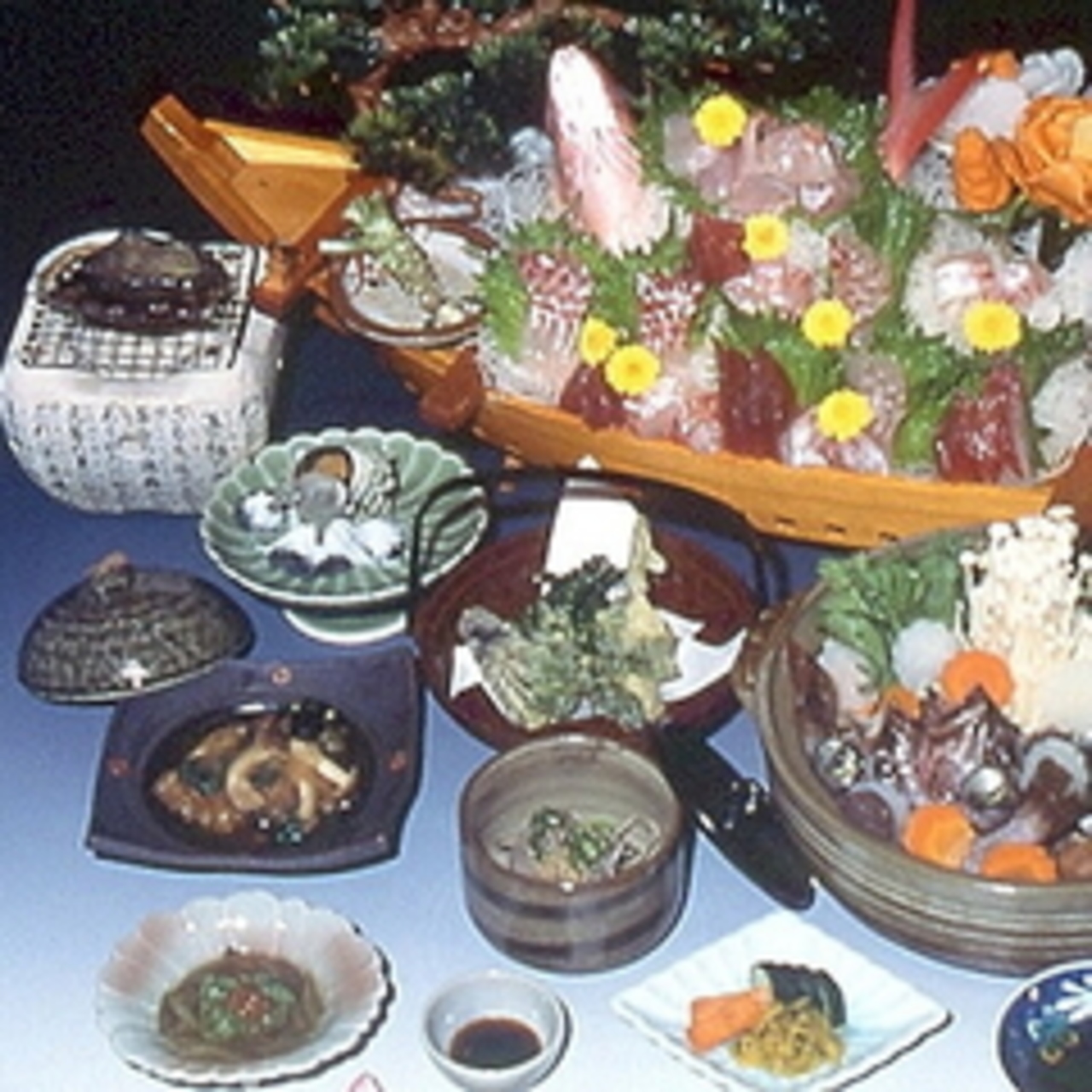 高見家のあわびコースの夕食。舟盛りにあわびや小鉢が並ぶ