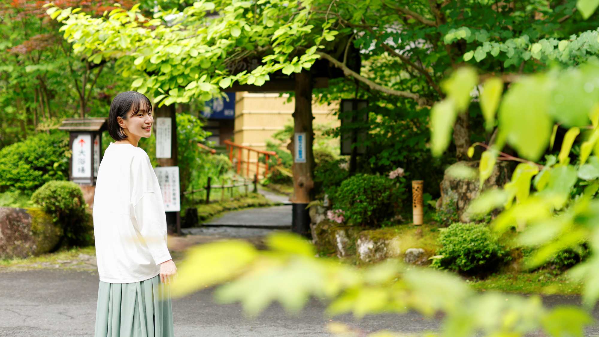 茅葺きの屋根が特徴的な「温泉入口」。広い敷地の園内を歩くのも楽しみのひとつ