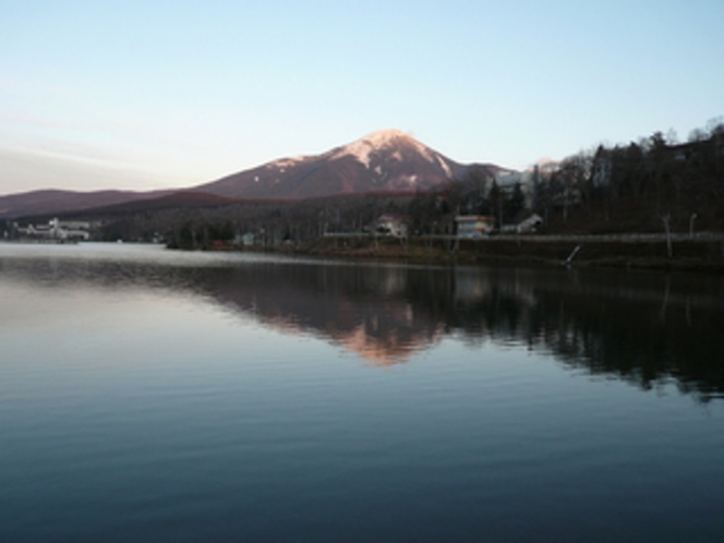 初冬夕暮れの白樺湖に映し出された蓼科山